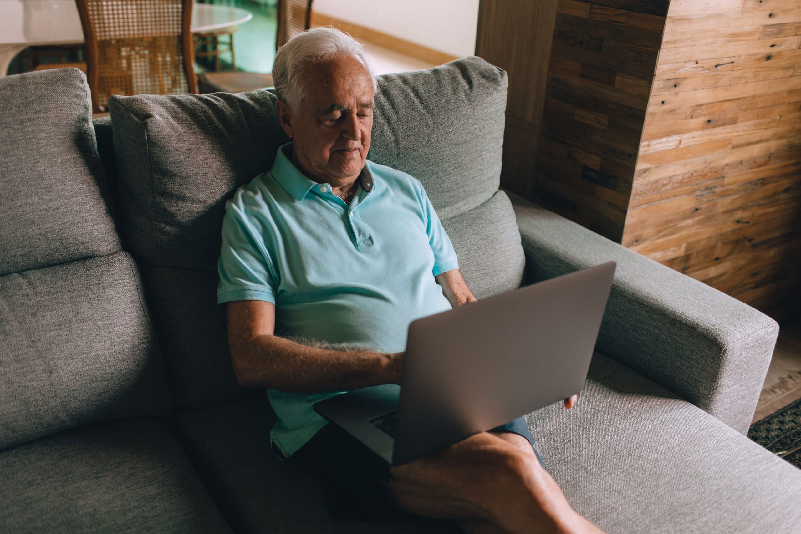 Older man using a laptop on the couch