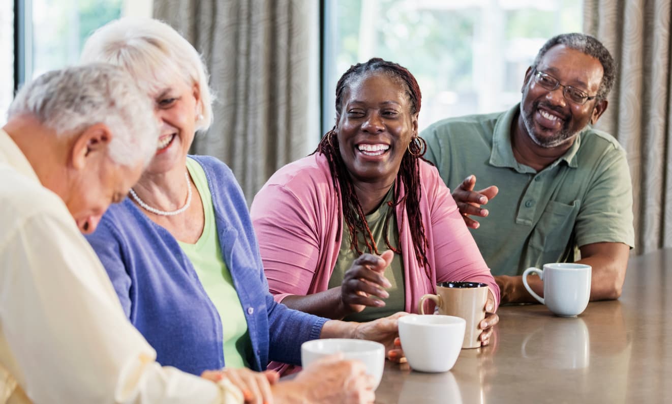 Four friends talking over coffee at a table