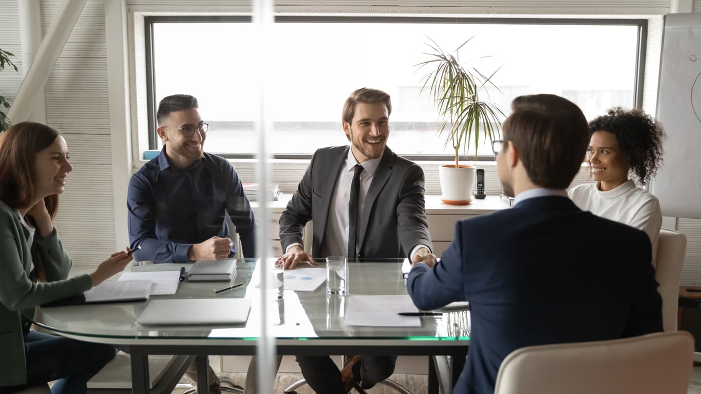 Two businessmen shaking hands in a meeting room