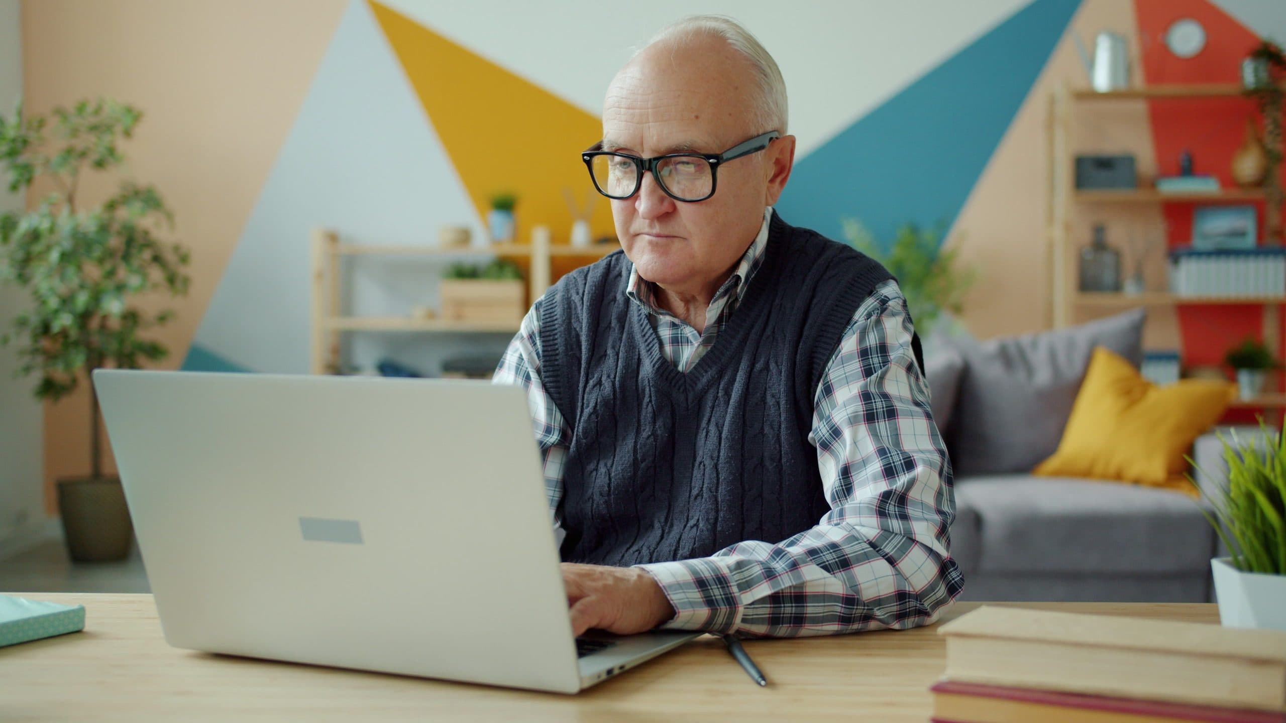 Older man working on a laptop in a home office