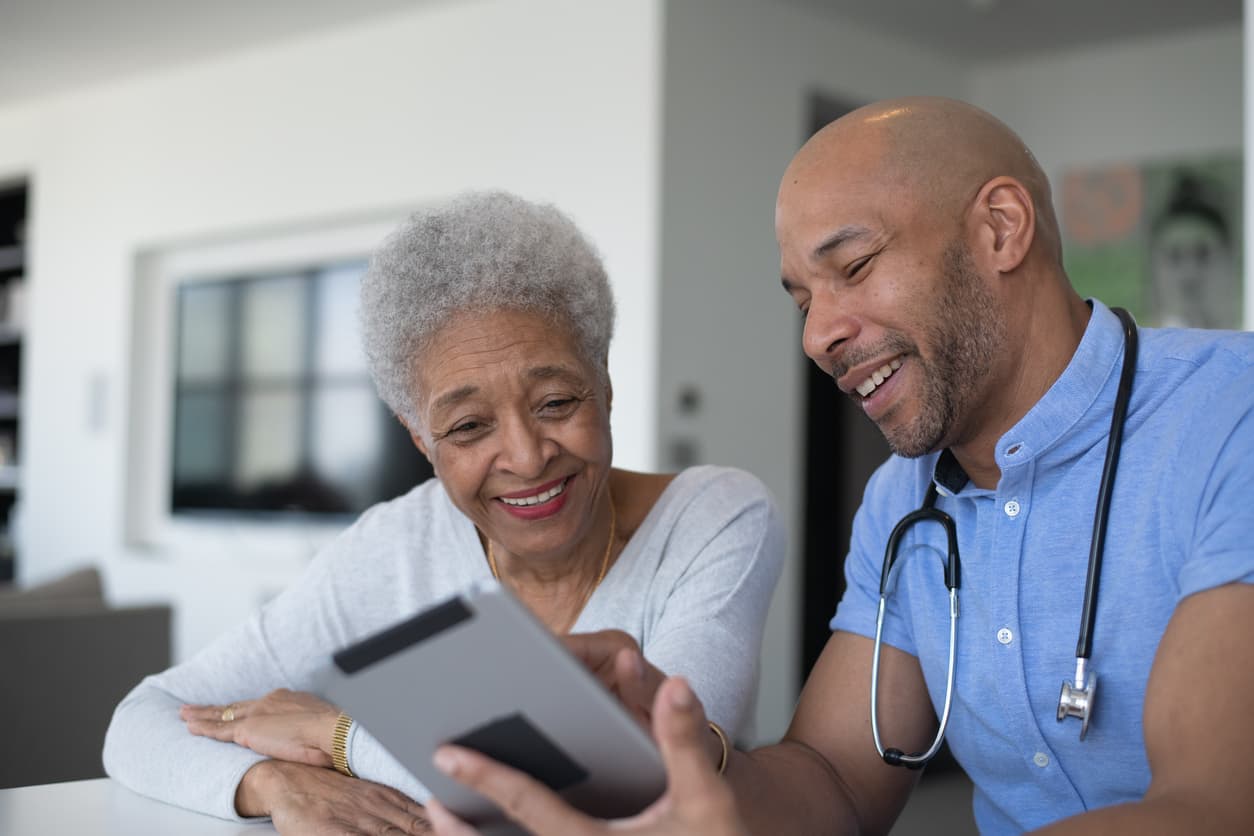 Doctor showing a tablet to an older patient
