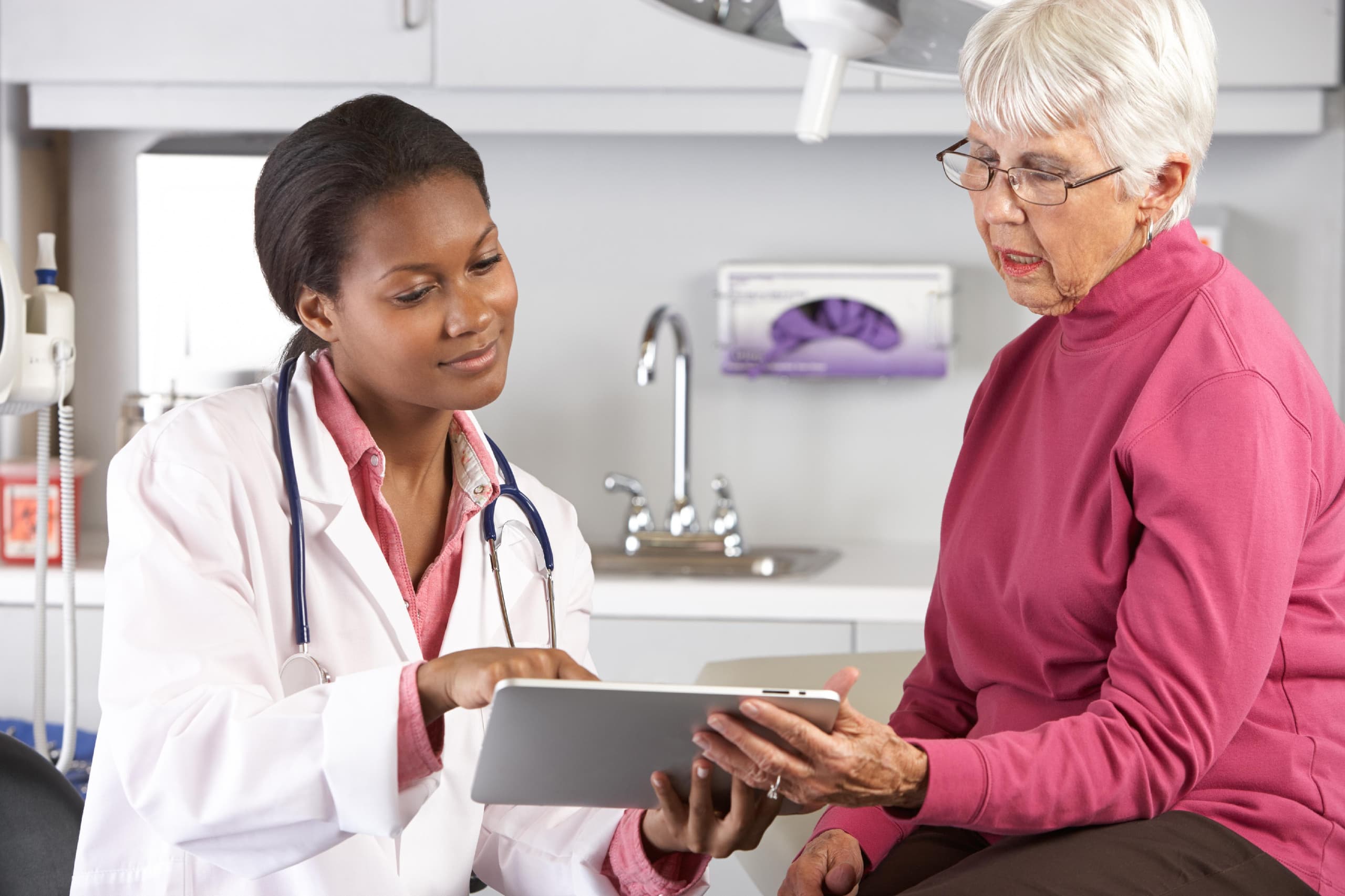A woman doctor explaining medical help to an older woman